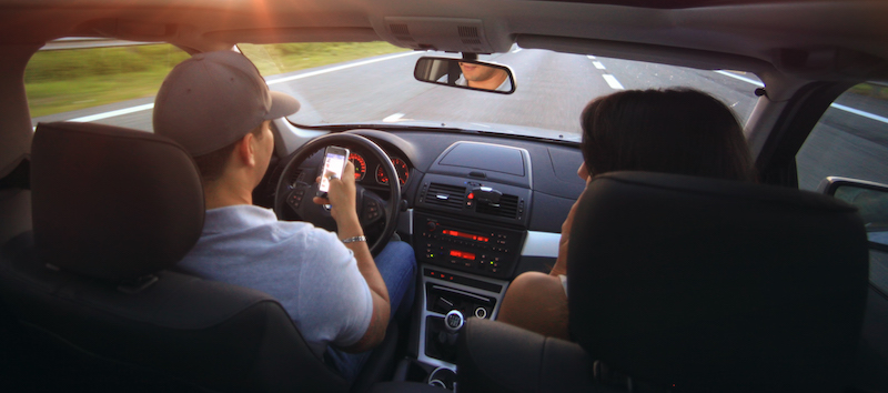 distracted driving awareness - man holding cell phone while driving